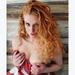 Edie Jeanne, Boston escort with strawberry blonde curls in a red wrap.
